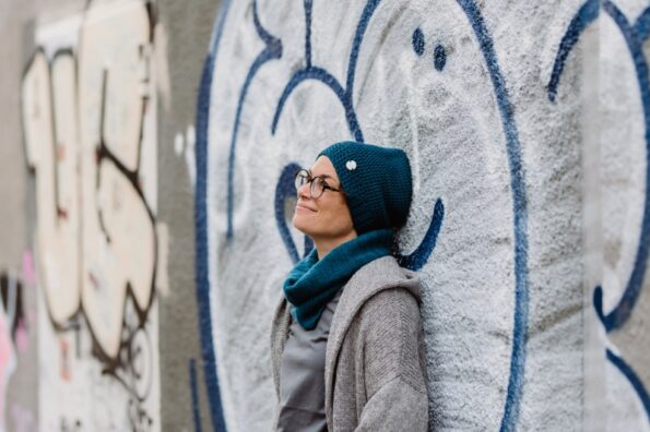 Katharina Mauder lehnt gegen eine Grafiti-Wand und sieht verträumt in die Ferne